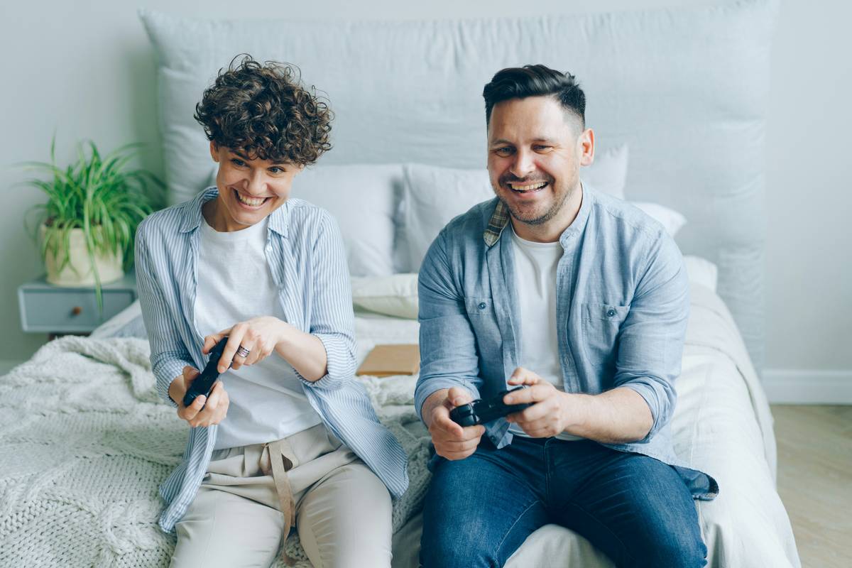 long distance couple enjoying competitive mobile games for couples on video call